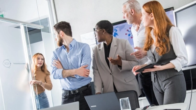 Eine Kollegin macht gestresst auf die Uhrzeit aufmerksam, weil sie noch so viel zu tun hat. Das kommt beim übrigen Team meist nicht gut an. (Foto: Christin Klose/dpa Themendienst/dpa-tmn)