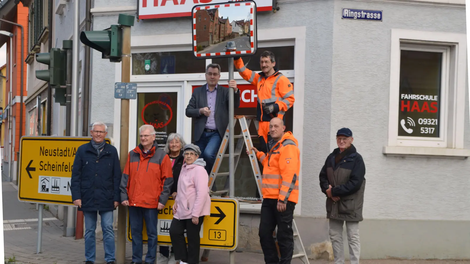 Bürgermeister Wolfgang Lampe (auf der Leiter links), Vertreter des Stadtbauhofs und des Seniorenbeirats weihten den heiß ersehnten Spiegel an der Uffenheimer B13-Stadthallenkreuzung feierlich ein. (Foto: Johannes Zimmermann)