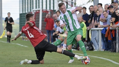 Szene aus dem Hinspiel zwischen dem SC Aufkirchen (in Rot) und dem FV Uffenheim: Tim Weigl versucht im Duell der beiden Kapitäne, Uwe Bößendörfer die Kugel vom Fuß zu kratzen. (Foto: Martin Rügner)
