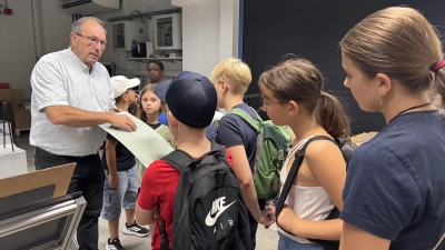 Eine Druckplatte zum Anfassen: Der technische Betriebsleiter Alexander Hieber zeigte den Kindern und Jugendlichen die verschiedenen Stationen im Druckhaus der FLZ. (Foto: Lara Hausleitner)