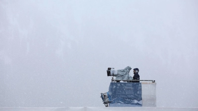 Ein Kameramann steht im Langlaufstadion im dichten Schneetreiben. (Foto: Karl-Josef Hildenbrand/dpa/Archivbild)