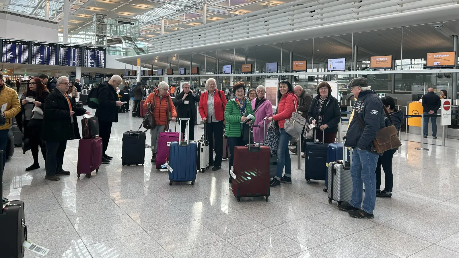 Einchecken am Flughafen München: FLZ-Chefredakteurin Gudrun Bayer (im pinken Mantel) hatte die 21-köpfige Gruppe im Bus von Ansbach bis zum Flughafen begleitet. (Foto: Ute Niephaus)