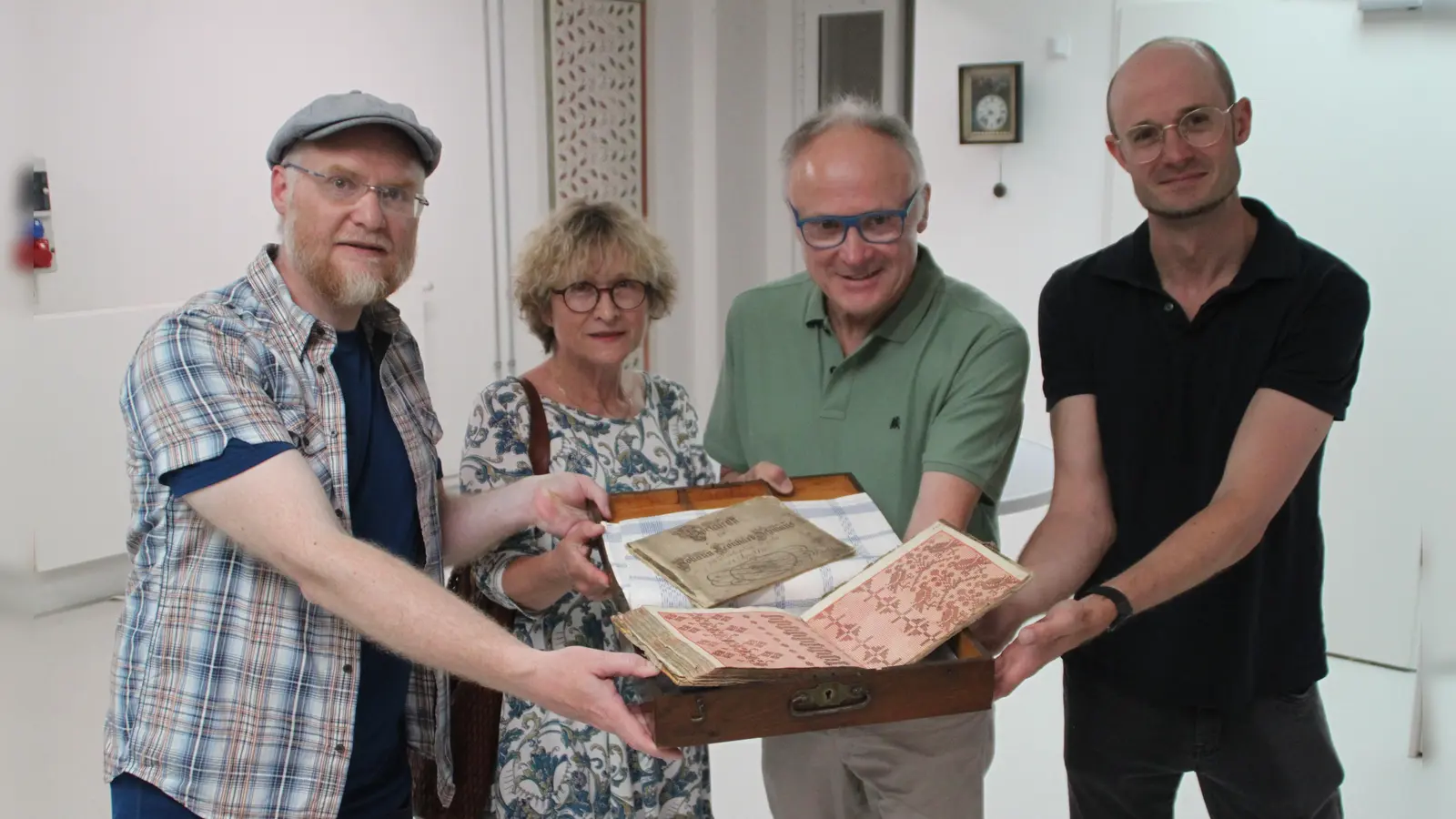 Robert Zöllner, Ulrike und Rudolf Weiß sowie Dr. Markus Rodenberg (von links) präsentieren das historische Webmusterbuch und das Vorschriftbüchlein. (Foto: Hans-Bernd Glanz)