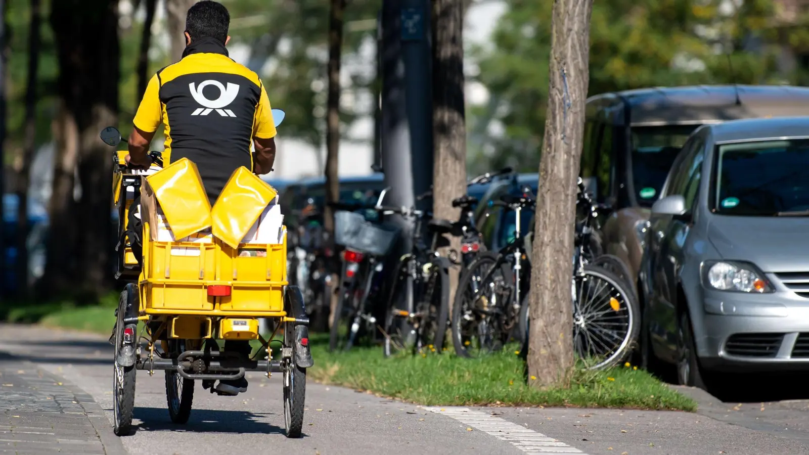 Ein Briefträger mit seinem Fahrrad: Im Jahr 2025 rechnet die Deutsche Post damit, dass fünf Briefe auf ein Paket kommen. (Foto: Sven Hoppe/dpa)