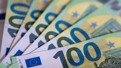 Eine Jugendliche verschenkt Bargeld ihres Vaters. (Symbolbild) (Foto: Monika Skolimowska/dpa)