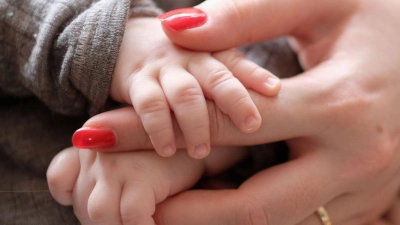 Eine Frau hält ein zwei Monate altes Baby im Arm. (Foto: Bernd Weißbrod/dpa/Symbolbild)