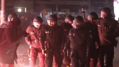 Polizei zwischen brennendem Feuerwerk auf der Straße in Berlin in der Silvesternacht.  (Foto: Julius Schreiner/dpa)