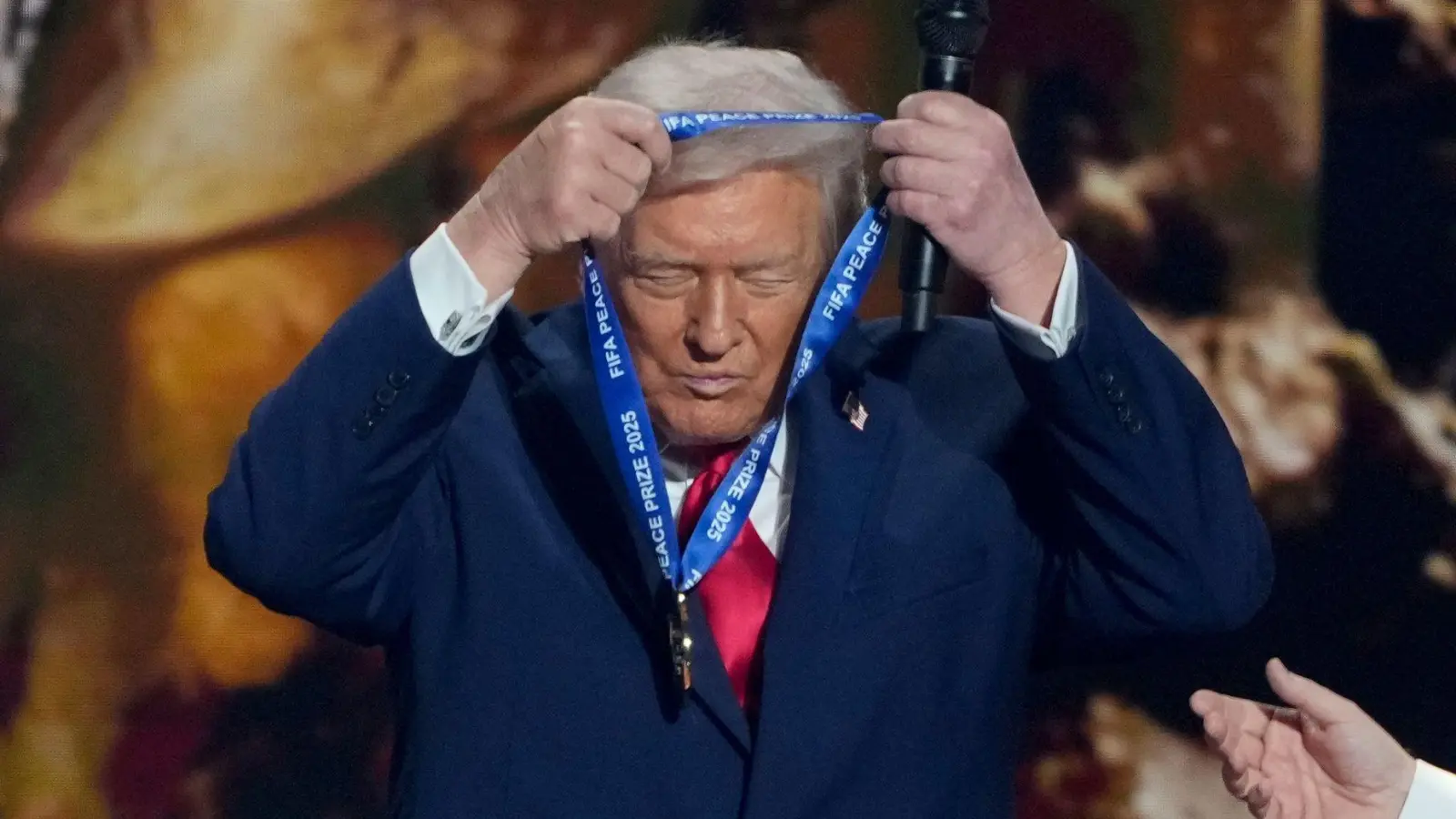US-Präsident Trump hängt sich die FIFA-Medaille selber um.  (Foto: Chris Carlson/AP/dpa)