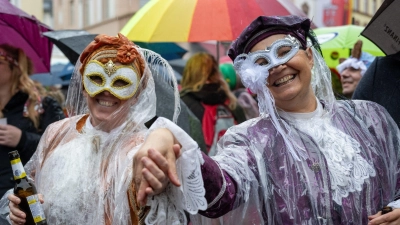 Narren auf dem Marktplatz in Wittlich an  Weiberfastnacht. Auch am Rosenmontag kann es nass werden. (Foto: Harald Tittel/dpa)