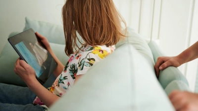 Eltern beeinflussen die Bildschirmzeit ihrer Kinder: Eine Studie zeigt, dass elterliches Verhalten und die Art der Kommunikation über Bildschirmnutzung eng mit dem Medienverhalten ihrer Kinder verknüpft sind. (Foto: Annette Riedl/dpa/dpa-tmn)