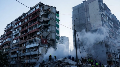 In den Trümmern eines bei einem russischen Angriff teils zerstörten Hauses suchen Helfer nach Verschütteten. (Foto: Evgeniy Maloletka/AP/dpa)