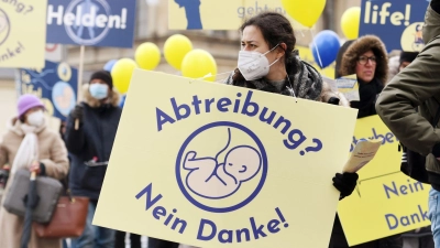 Eine Frau nimmt an einer Demonstration von Abtreibungsgegnern unter dem Titel „Marsch fürs Leben” teil und trägt ein Schild mit der Aufschrift „Abtreibung? Nein Danke!”. (Foto: Tobias Hase/dpa)