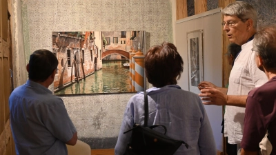 Ausstellungskurator Manfred Hönig erklärt eines seiner fotorealistischen Bilder. Die Ausstellung trägt das Thema Wasser. (Foto: Judith Marschall)