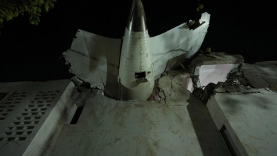 Das Heck des Flugzeugs steckt in einem Gebäude an der Absturzstelle in der nordwestindischen Stadt Ahmedabad im Bundesstaat Gujarat. (Foto aktuell) (Foto: Ajit Solanki/AP/dpa)