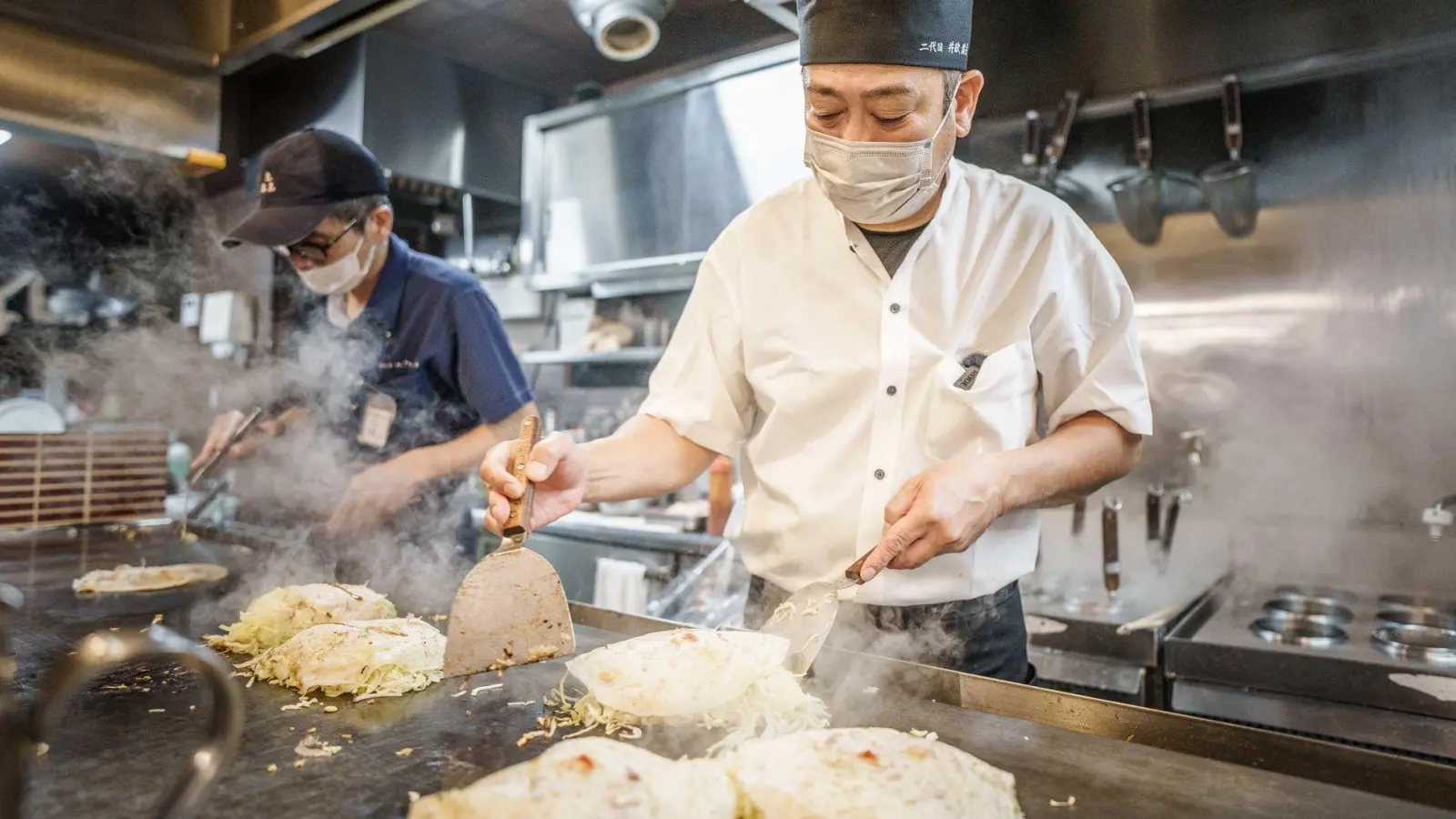 Okonomiyaki ist ein japanisches Gericht. Okonomi bedeutet „was du magst“, yaki bedeutet „gebraten“ oder „gegrillt“. Traditionell wird Okonomiyaki am Tisch auf einer heißen Eisenplatte mit einem Spatel gebraten. (Foto: Michael Kappeler/dpa/dpa-tmn)