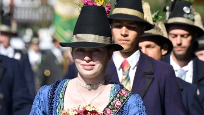 Eine Frau trägt an Mariä Himmelfahrt einen aus zahlreichen Kräutern und Blumen gebundenen Strauß. (Archivbild) (Foto: Uwe Lein/dpa)
