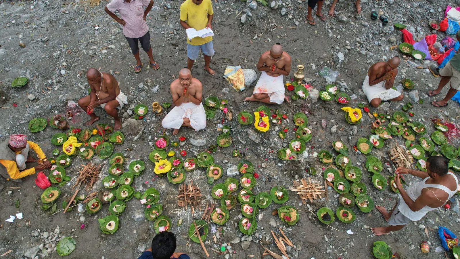 Menschen, deren Angehörige nach den Sturzfluten weiterhin vermisst werden, vollziehen am Ufer des angeschwollenen Trishuli-Flusses im nepalesischen Distrikt Nuwakot Rituale im Anschluss an symbolische Bestattungszeremonien. (Foto: Rajesh Kumar Singh/AP/dpa)