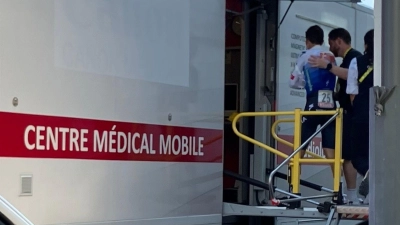 Florian Lipowitz (l) betritt den Medical Truck der Tour de France. (Foto: Stefan Tabeling/dpa)