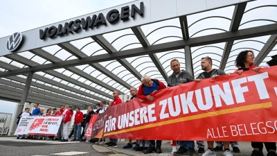 Vor der Betriebsversammlung von VW in Zwickau demonstrieren Beschäftigte am Werkstor. (Foto: Hendrik Schmidt/dpa)