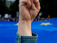 Eine Frau zeigt ein Siegeszeichen mit der Flagge der Europäischen Union im Hintergrund während einer Wahlkampfveranstaltung des rumänischen Präsidentschaftskandidaten Dan, eine Woche vor der zweiten Runde der Präsidentschaftswahlen. (Foto: Andreea Alexandru/AP/dpa)
