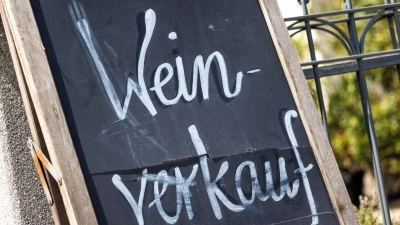 Ein Schild mit der Aufschrift „Weinverkauf“ lehnt an einem Zaun. (Foto: Matthias Balk/dpa/Symbolbild)