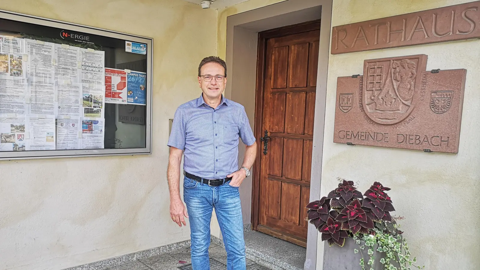 Andreas Schott vor dem Eingang zum Diebacher Rathaus: Dort spielt sich nur ein geringerer Teil seiner Tätigkeit als ehrenamtlicher Bürgermeister der Gemeinde ab. (Foto: Jürgen Binder)