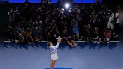 Aryna Sabalenka präsentiert den Fotografen ihren Pokal. (Foto: Seth Wenig/AP/dpa)