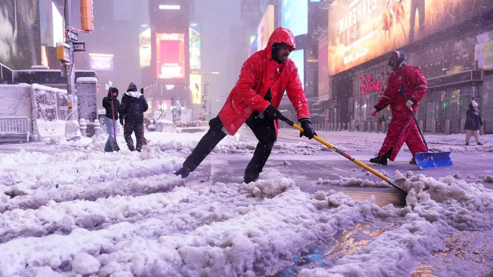 Ein Arbeiter schaufelt Schnee auf dem Times Square in New York. Ein heftiger Schneesturm zieht über den Nordosten der USA hinweg. (Foto: Seth Wenig/AP/dpa)