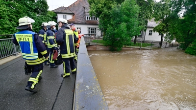 Rezathochwasser am 9. Juli 2021: Feuerwehrleute schauen vom Steg an der Schloss-Bibliothek auf die Fluten auf dem Rezatparkplatz. (Foto: Jim Albright)