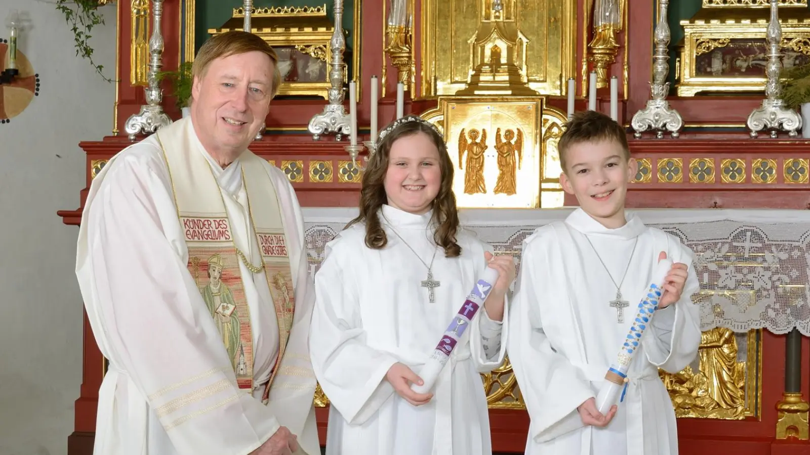 In der geschmückten Wallfahrtskirche in Großlellenfeld haben zwei Kinder mit Pfarrer Reinhard Pasel ihre Erste Heilige Kommunion erhalten. (Foto: Atelier Braun)