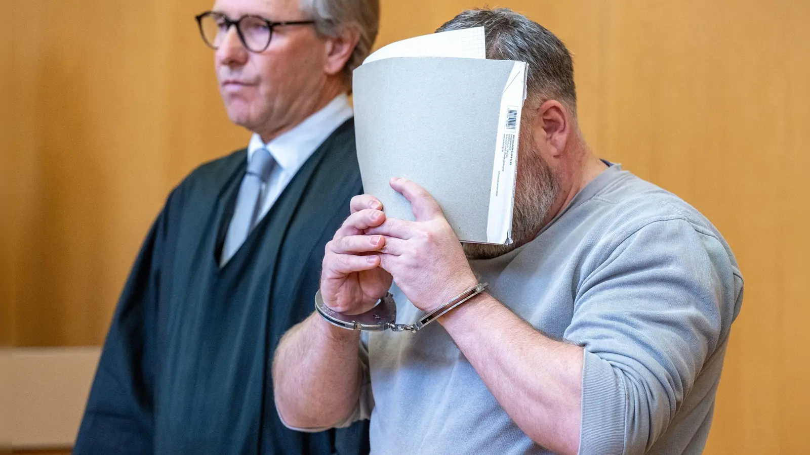 Der 45 Jahre Angeklagte verbirgt im Gerichtssaal sein Gesicht. (Foto: Armin Weigel/dpa)