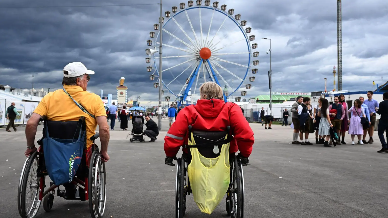 Werner Graßl (l) und Monika Burger auf dem Weg zum Riesenrad. (Foto: Felix Hörhager/dpa)