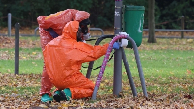 Feuerwehrleute überprüfen eine Mülltonne. (Foto: David Young/dpa)