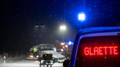 Auf der verschneiten Bundesstraße 12 warnt an einer Unfallstelle ein Polizeifahrzeug vor Glätte.  (Foto: Stefan Puchner/dpa)