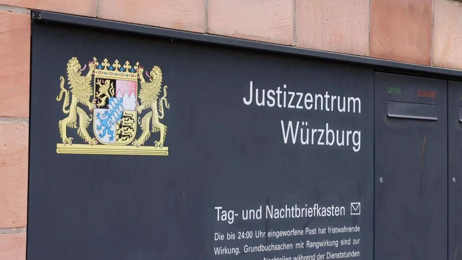 Blick auf ein Hinweisschild am Justizzentrum Würzburg. (Foto: Heiko Becker/dpa)