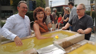 Ließen eine Gummi-Ente im Armbecken schwimmen: Stadträtin Angela Beck und ihre Enkelin Rahel. Die Kollegen Herbert Lindörfer (links) und Friedrich Probst sahen dabei zu. (Foto: Peter Zumach)