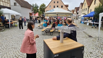 Da war's noch trocken: Kaum hatten Museumschefin Dr. Laura Gebauer und Bürgermeister Markus Liebich (vorn) den Gedenkmünzen-Apparat enthüllt, setzte Regen ein und machte das Museumsfest Am Plan ungemütlich. (Foto: Wolfgang Grebenhof)