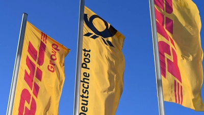 Eine Deutsche-Post-Fahne an der Konzernzentrale, umrahmt von DHL-Fahnen. (Foto: Wolf von Dewitz/dpa)