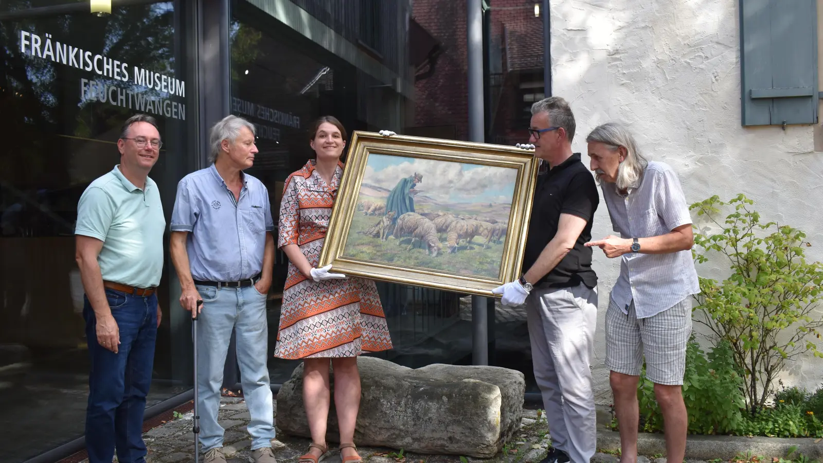 Bei der Übergabe des Sperling-Gemäldes vor dem Fränkischen Museum: Dessen Leiterin Dr. Uta Karrer und der Vorsitzende des Vereins für Volkskunst und Volkskunde, Feuchtwangens Bürgermeister Patrick Ruh (Mitte), nahmen das Kunstwerk von Herbert Lindörfer, Dr. Stefan Mühling und Erich Herrmann (von links) von der Arbeitsgemeinschaft „Feuchtwanger Kalender“ entgegen. (Foto: Rebecca Weber)