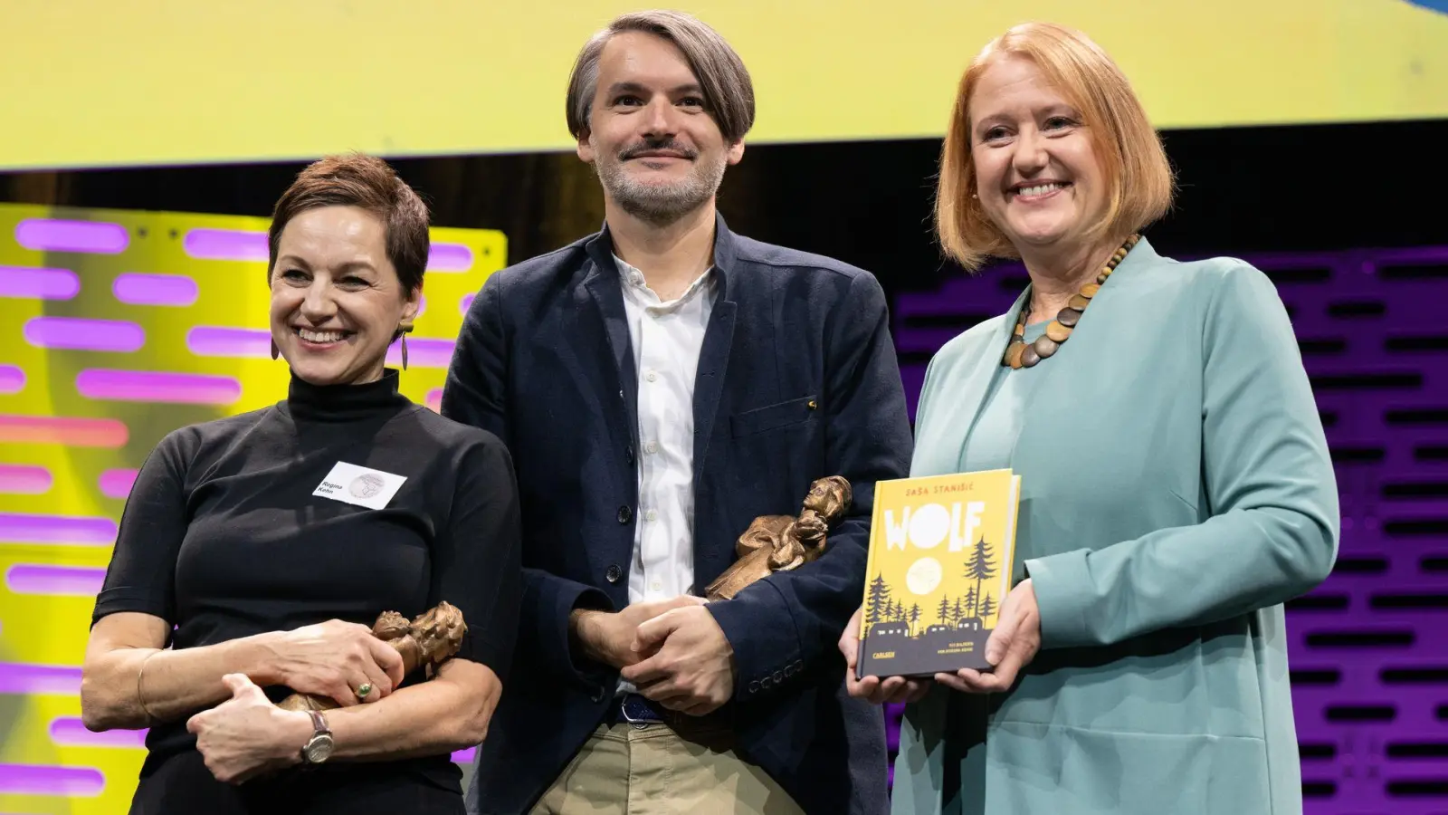 Der Schriftsteller Saša Stanišić und die Illustratorin Regina Kehn (links) haben den Jugendliteraturpreis für ihr Kinderbuch „Wolf“ gewonnen. (Foto: Boris Roessler/dpa)