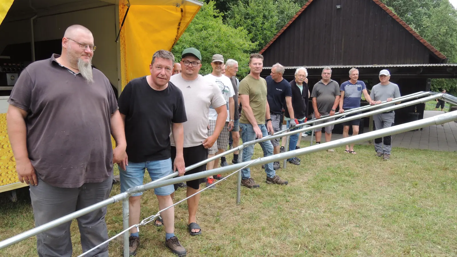 Beim Aufstellen des Bierzelts neben der Fischerhütte (vorne von links): die Vorsitzenden Markus Präger von der Freiwilligen Feuerwehr Dorfgütingen, Norbert Leixner von der Schützengesellschaft und Johann Sokolov vom Fischereiverein zusammen mit Mitgliedern der drei Vereine. (Foto: Peter Zumach)