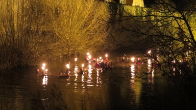 Vor Dinkelsbühls Stadtmauer als imposanter Kulisse: Bei einer Wassertemperatur um die vier Grad legten die Fackel-Schwimmerinnen und Fackelschwimmer rund einen Kilometer in der Wörnitz zurück. (Foto: Alexander Schäffer)