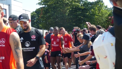 Im Kreis der Mannschaft: Auch für FCN-Athletiktrainer Gerald Stürzehofecker (links vorne) galt es beim öffentlichen Training, das Spalier der zahlreichen Club-Fans zu durchschreiten. (Foto: Herbert Ruff)