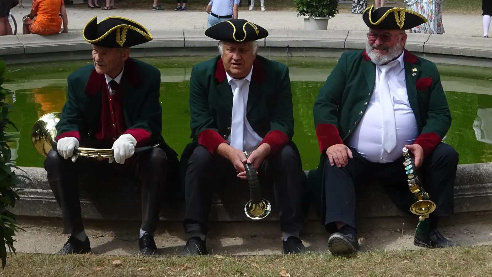 Warme Temperaturen und die Uniformen machen den Musikanten zu schaffen. Da ist eine kurze Pause freilich erlaubt. (Foto: Florian Pöhlmann)