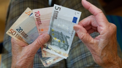 Eine ältere Frau zählt Geld. (Foto: Marijan Murat/dpa/Symbolbild)