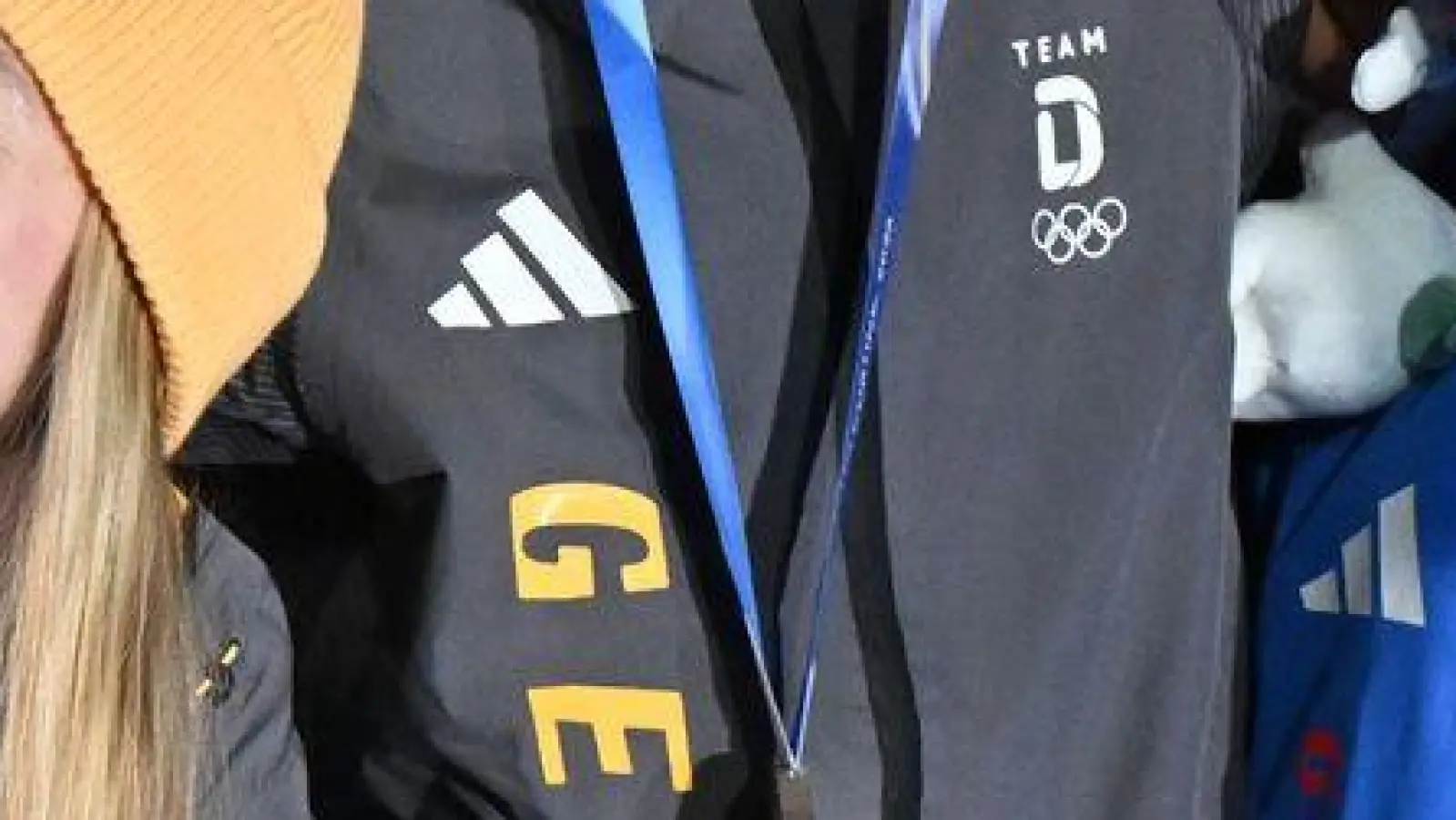 Tabitha Stoecker (Großbritannien) und Matt Weston (Großbritannien, beide M) posieren bei der Siegerehrung ihren Goldmedaillen nach dem Skeleton-Team-Wettbewerb neben Susanne Kreher (Deutschland, l) und Axel Jungk (Deutschland, 2.v.l.) mit der Silbermedaille und Jacqueline Pfeifer (Deutschland, 2.v.r.) und Christopher Grotheer (Deutschland) mit der Bronzemedaille bei den Olympischen Winterspielen Mailand Cortina 2026. (Foto: Robert Michael/dpa)