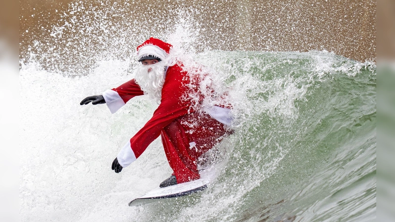 Surflehrer und Rettungsschwimmer Finn Clark aus Gorebridge verkleidet sich als Weihnachtsmann für eine Surfsession im Lost Shore Surf Resort in Newbridge, in der Nähe von Edinburgh. (Foto: Jane Barlow/PA Wire/dpa)