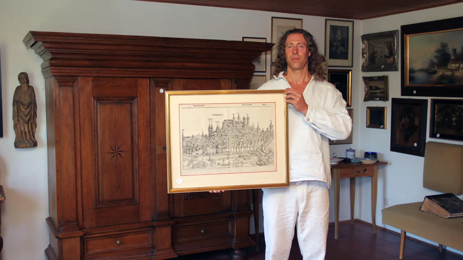 Michael Bamberger, Juniorchef des Nürnberger Auktionshauses Bamberger, zeigt das prominenteste Stück aus dem Nachlass des Grafikers und Sammlers Rudi Lösel: Einen Holzschnitt mit einer Gesamtansicht Nürnbergs aus der Schedelschen Weltchronik von 1493. (Foto: Yvonne Neckermann)