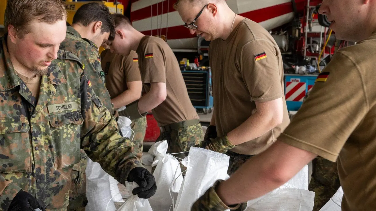 In einem Betonwerk füllen Soldaten der Bundeswehr Sandsäcke ab. (Foto: Stefan Puchner/dpa)